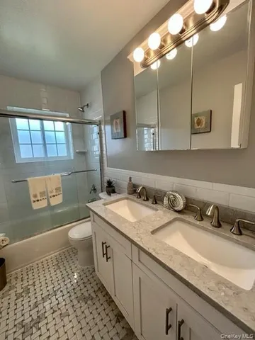 a bathroom with a sink a toilet and mirror