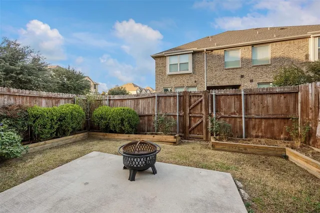 a backyard of a house with fountain table and chairs