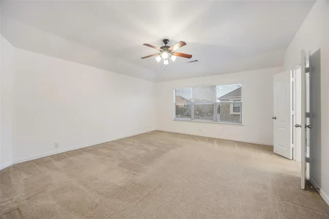 an empty room with a empty space and a ceiling fan