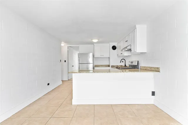 a view of kitchen with stainless steel appliances granite countertop lots of white cabinets