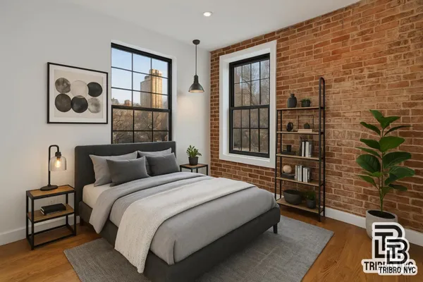 a bedroom with a bed and a potted plant next to a window