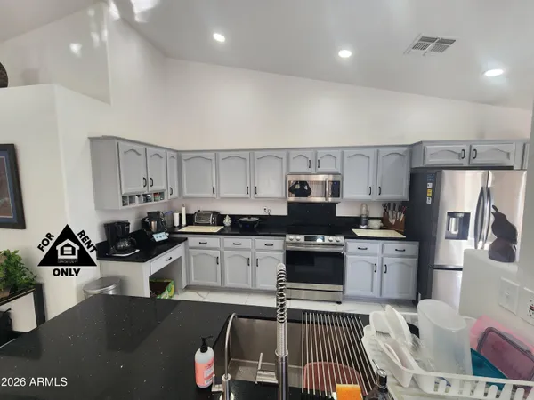 a kitchen with stainless steel appliances granite countertop a sink a stove and refrigerator