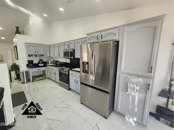 a kitchen that has a lot of cabinets a sink and appliances