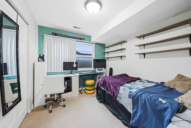 a bedroom with a bed and a desk