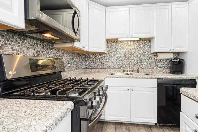 a kitchen with sink a stove and cabinets