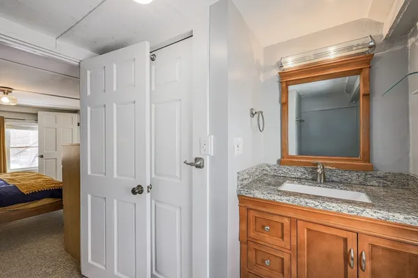 a en suite bathroom with a granite countertop sink and a mirror
