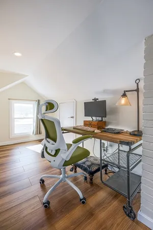 a view of a workspace with furniture and a window