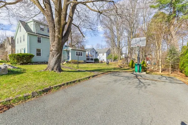 a view of a house with a large tree and a yard