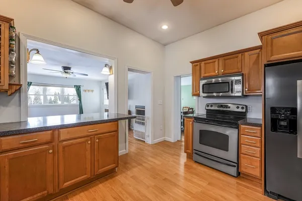 a kitchen with stainless steel appliances granite countertop a stove a sink and a microwave