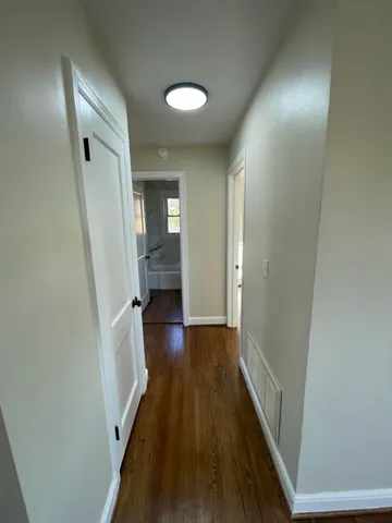 a view of a hallway with wooden floor and staircase