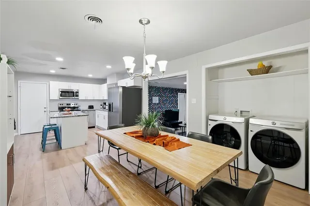 a view of a dining room with furniture a rug and kitchen view