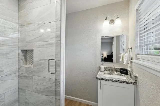 a bathroom with a granite countertop sink a toilet and shower