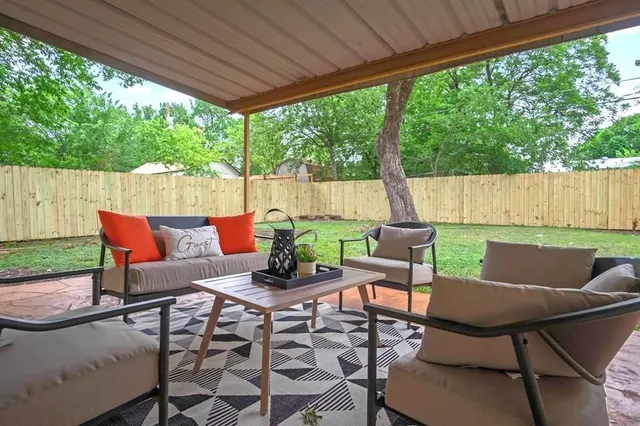 a view of a patio with table and chairs with wooden floor and fence