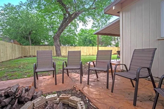 a view of a chairs and table in backyard of the house
