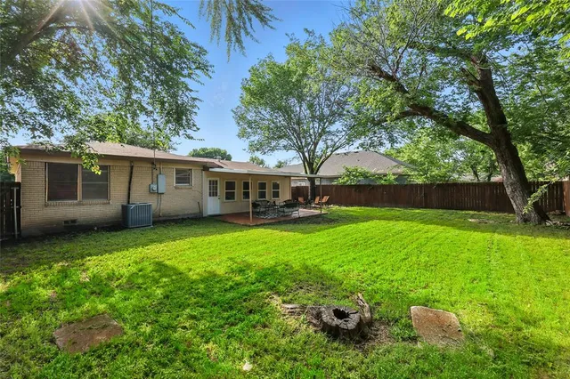 a view of a house with backyard and a tree
