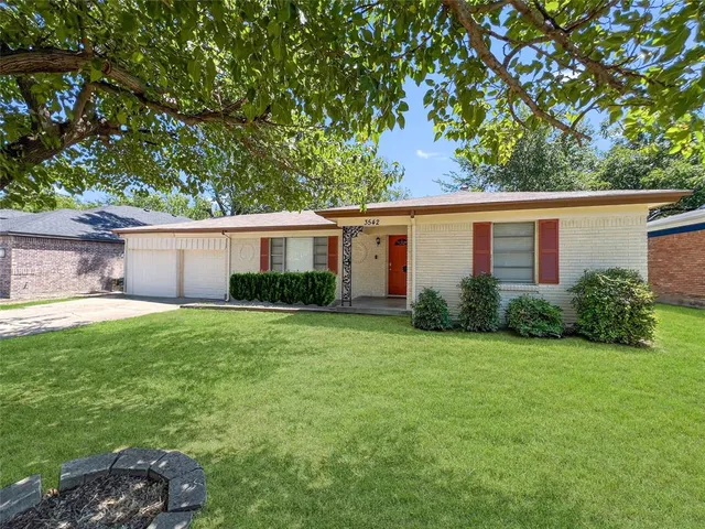 a view of a house with backyard and a tree