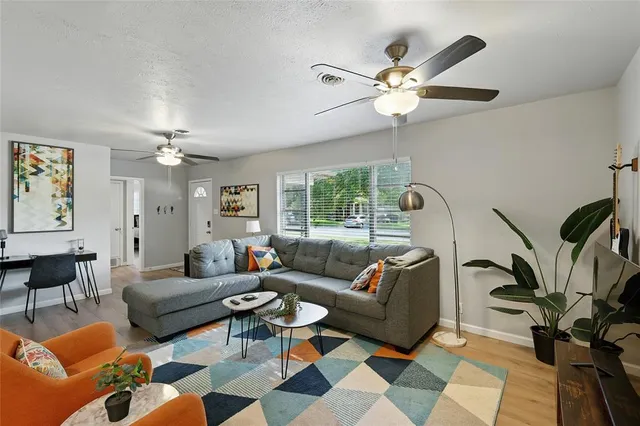 a living room with furniture a chandelier and a rug