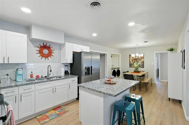a kitchen with stainless steel appliances granite countertop a refrigerator and a stove top oven