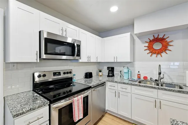 a kitchen with stainless steel appliances granite countertop a stove and a microwave