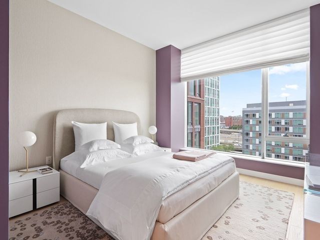 a large bedroom with a large bed and a large window