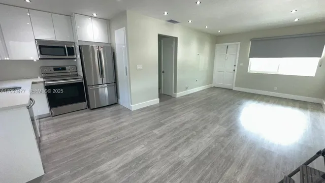 a kitchen with stainless steel appliances a refrigerator and a stove top oven