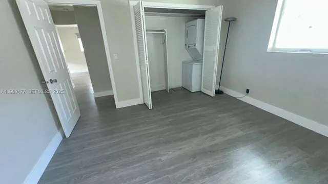 an empty room with wooden floor and a window