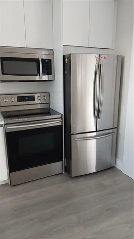 a metallic refrigerator freezer sitting in a kitchen