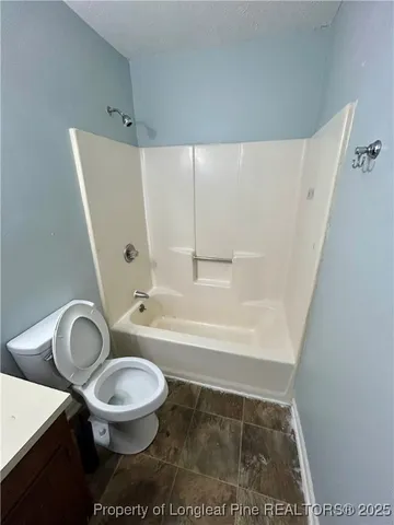 a white toilet sitting next to a bath tub