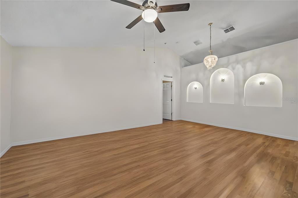 8453 Apple Orchard Road Spring Hill, FL 34608 - Photo 16 of 66 a view of a room with wooden floor and white walls