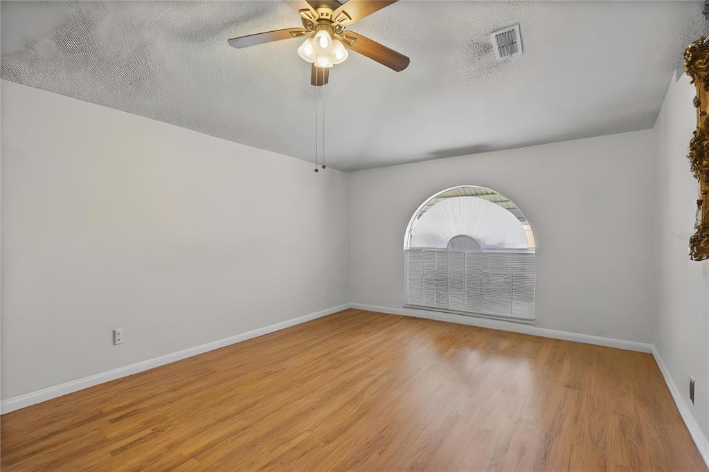 8453 Apple Orchard Road Spring Hill, FL 34608 - Photo 17 of 66 wooden floor in an empty room with a window