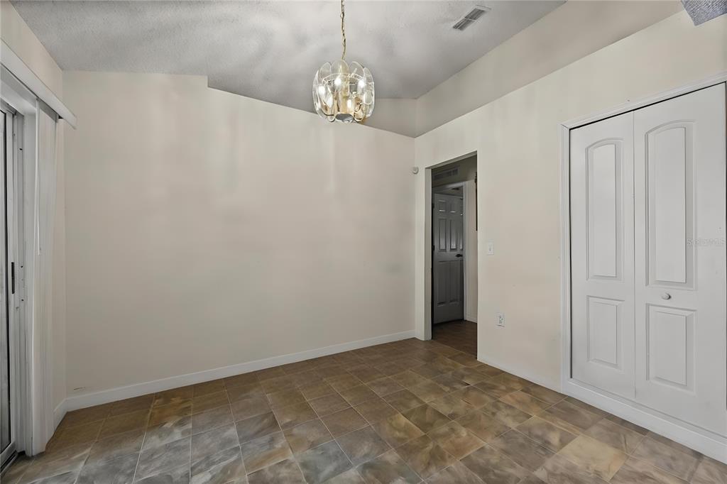 8453 Apple Orchard Road Spring Hill, FL 34608 - Photo 19 of 66 a view of an empty room with window and chandelier fan