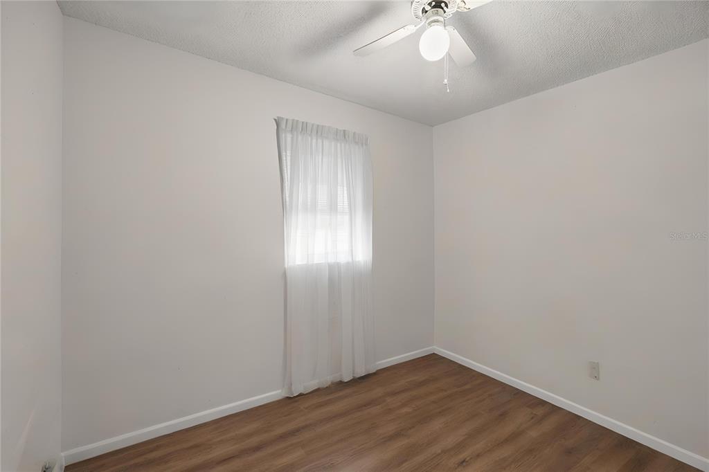 8453 Apple Orchard Road Spring Hill, FL 34608 - Photo 25 of 66 an empty room with wooden floor and windows