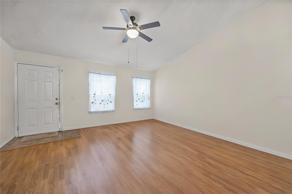 8453 Apple Orchard Road Spring Hill, FL 34608 - Photo 30 of 66 an empty room with wooden floor fan and windows
