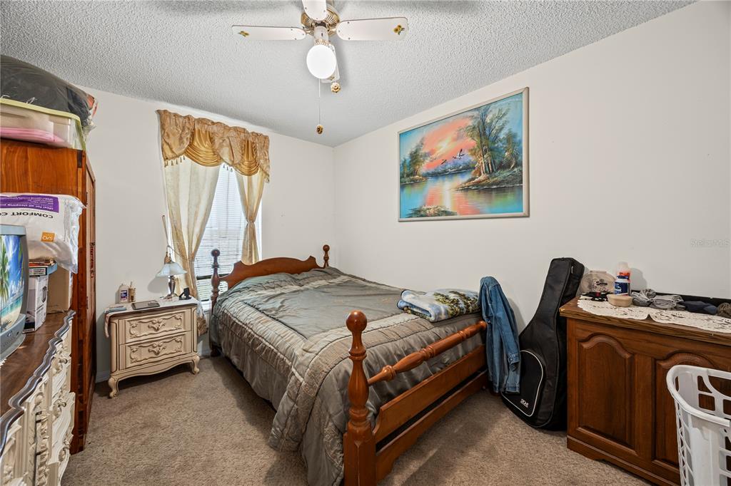8453 Apple Orchard Road Spring Hill, FL 34608 - Photo 47 of 66 a bed room with a bed and a chandelier