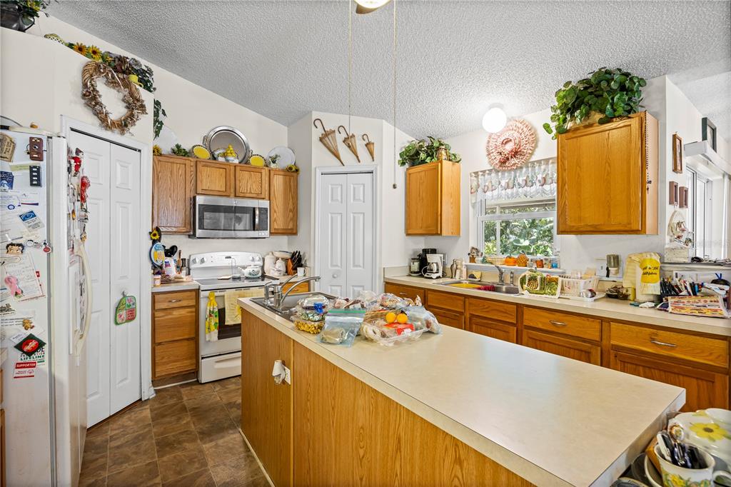 8453 Apple Orchard Road Spring Hill, FL 34608 - Photo 57 of 66 a kitchen with stainless steel appliances kitchen island granite countertop a sink stove and refrigerator