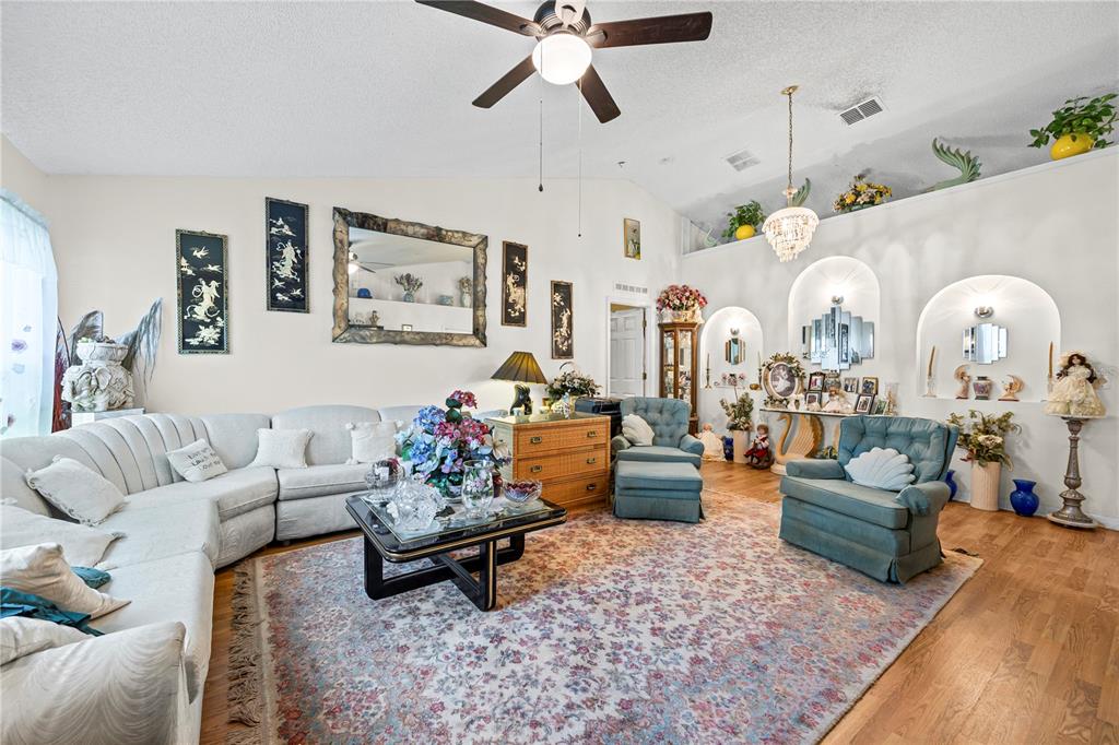 8453 Apple Orchard Road Spring Hill, FL 34608 - Photo 59 of 66 a living room with furniture and a chandelier
