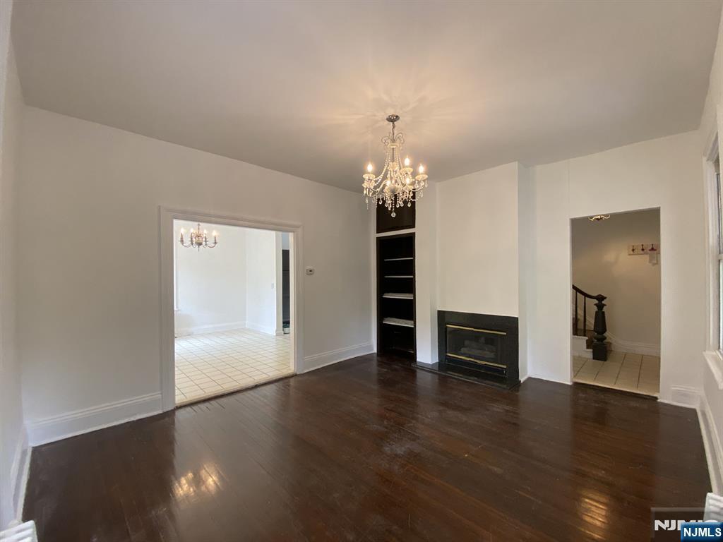 59 Forest Street Alpine, NJ 07620 - Photo 4 of 16 an empty room with wooden floor chandelier and windows