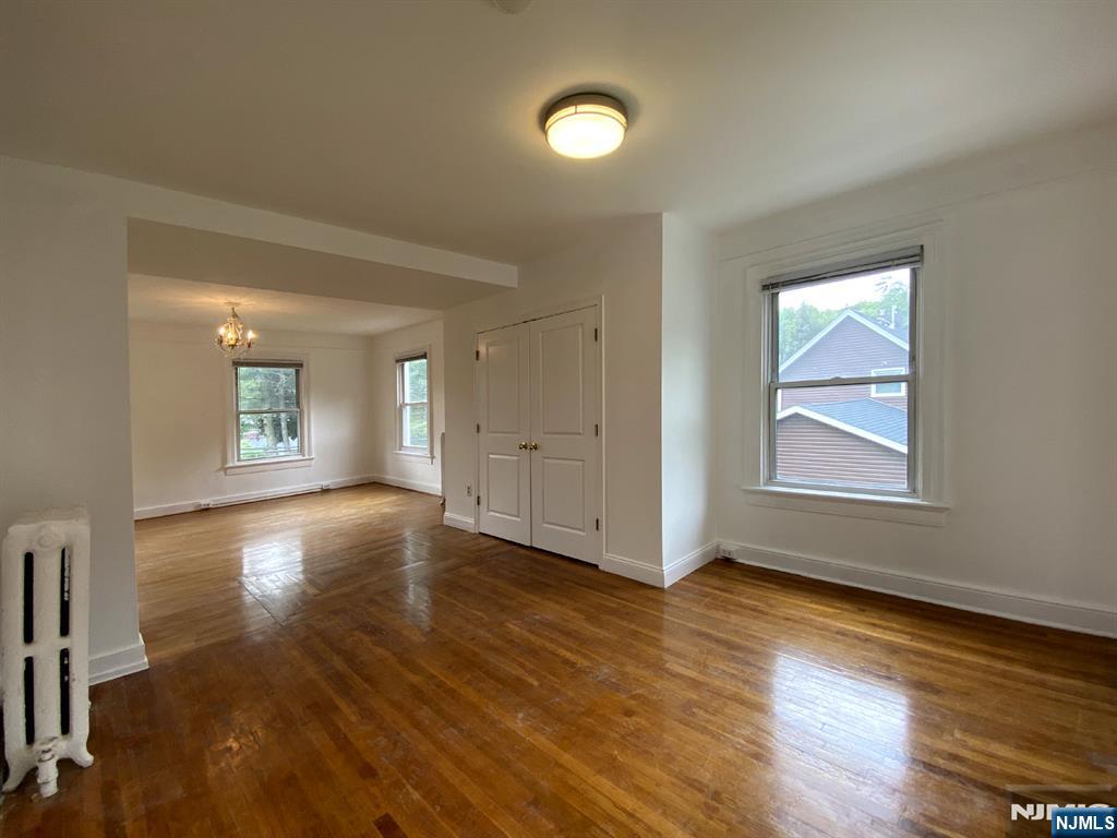 59 Forest Street Alpine, NJ 07620 - Photo 9 of 16 an empty room with wooden floor and windows