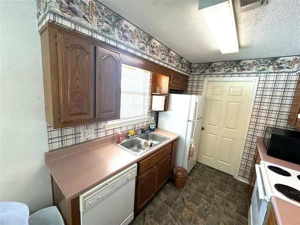 a kitchen that has a sink a stove and a refrigerator