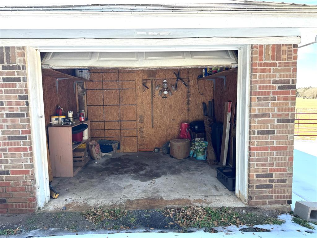 205 County Road 1135 Ravenna, TX 75476 - Photo 5 of 30 Garage at the front has storage. Behind wall was closed in to make additional room. Has no heat and air to it just a room with electrical. Access to room from inside home.