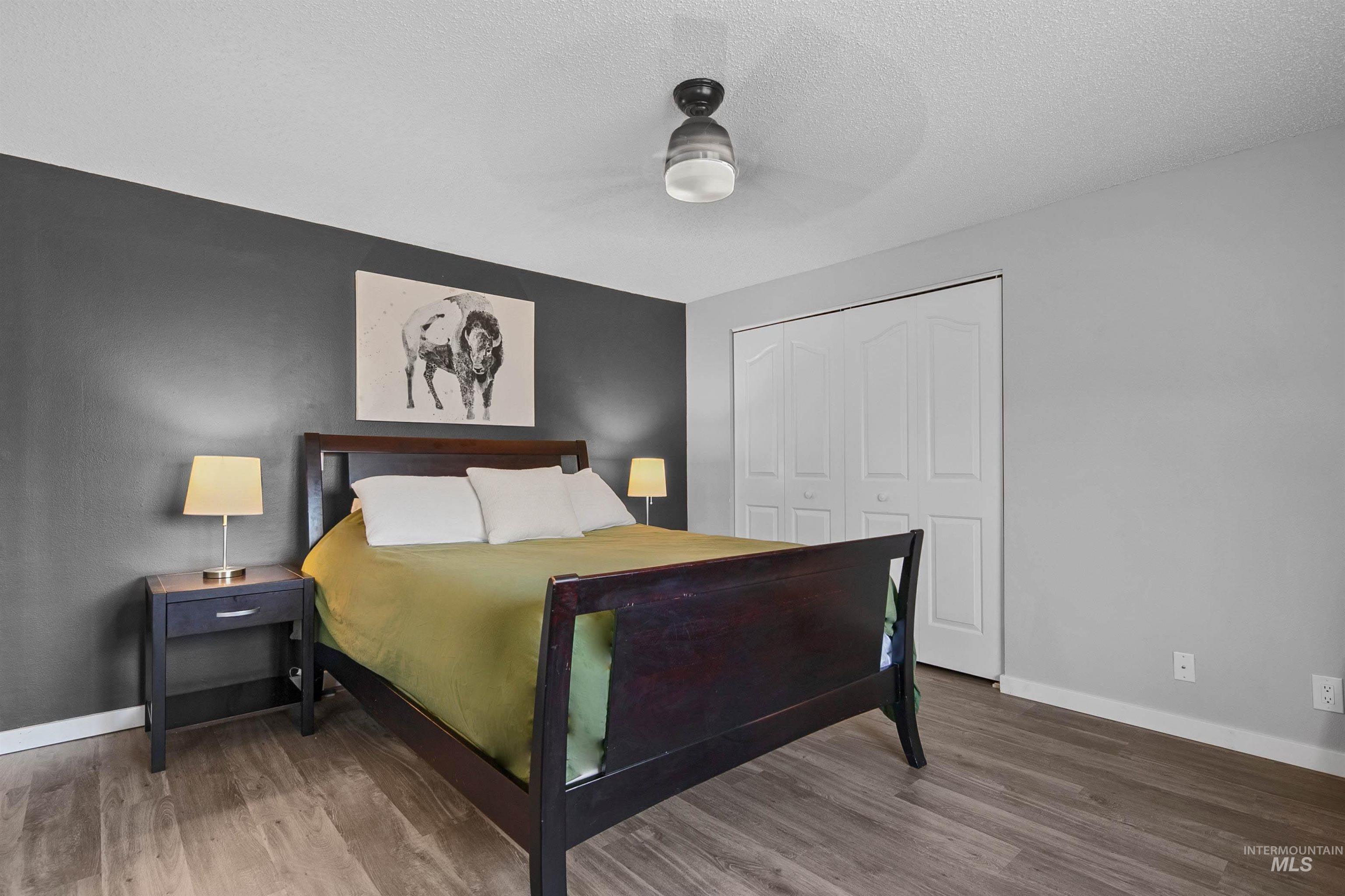 3651 South Gekeler Lane, Unit 96 Boise, ID 83706 - Photo 19 of 38 Bedroom featuring a closet, wood finished floors, ceiling fan, and a textured ceiling