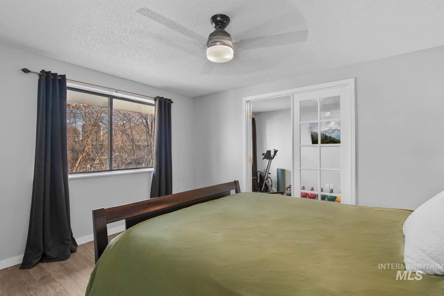3651 South Gekeler Lane, Unit 96 Boise, ID 83706 - Photo 20 of 38 Bedroom featuring a textured ceiling, a ceiling fan, wood finished floors, and a closet