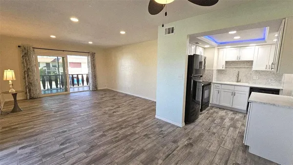 a open kitchen with stainless steel appliances granite countertop a refrigerator and a sink