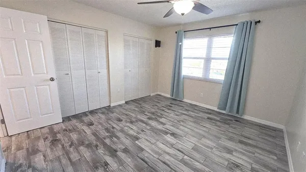 a view of empty room with window and ceiling fan