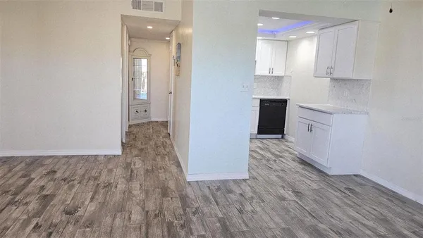 a view of a kitchen with wooden floor and cabinets