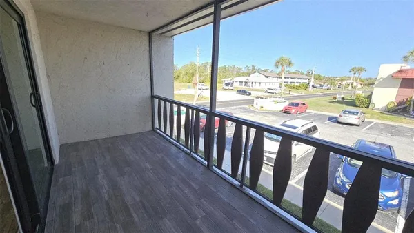 a view of a balcony with chair and wooden floor