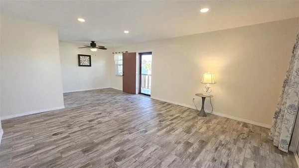 a view of empty room with wooden floor
