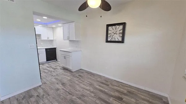 wooden floor in an empty room with a kitchen