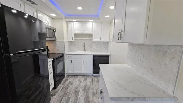 a kitchen with a sink stainless steel appliances and cabinets