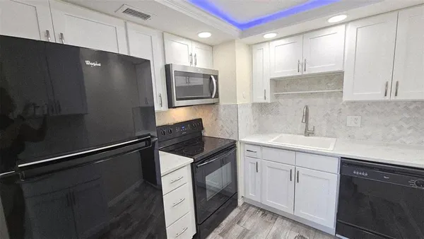 a kitchen with a refrigerator sink and cabinets